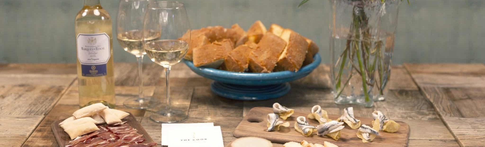 regalo gourmet con flores, vino y picoteo